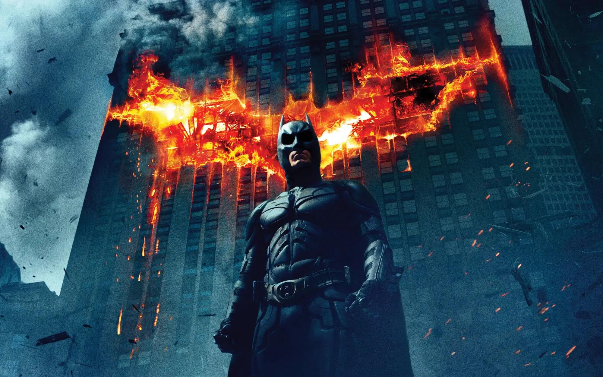 Batman before a blazing building, while sustainable supply chain solutions work behind the scenes.