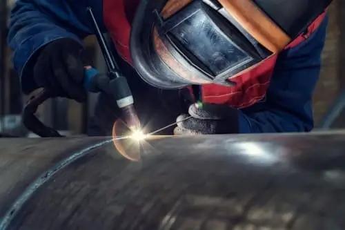 A welder doing his job in the context of the automotive packaging logistics industry.