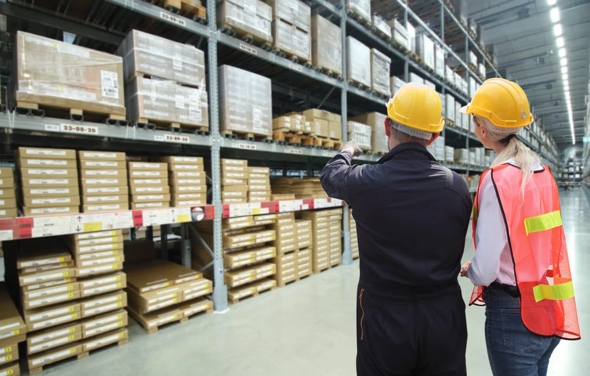 Warehouse worker using RFID handheld reader to track inventory.