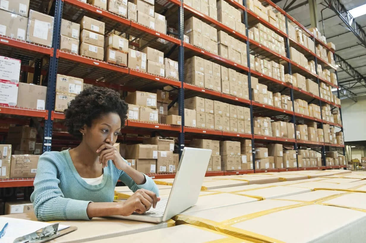 Woman using supply chain visibility software for data consolidation.